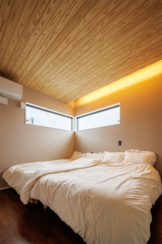 天井に優しい雰囲気の木目を配置した寝室