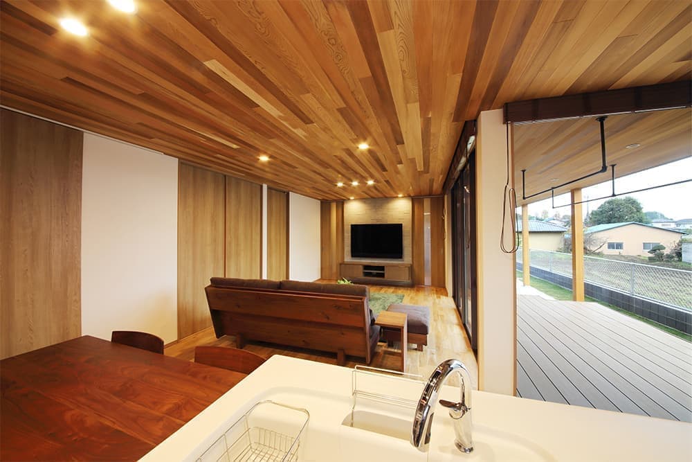 レッドシダーの深い軒とデッキテラスのある平屋の家