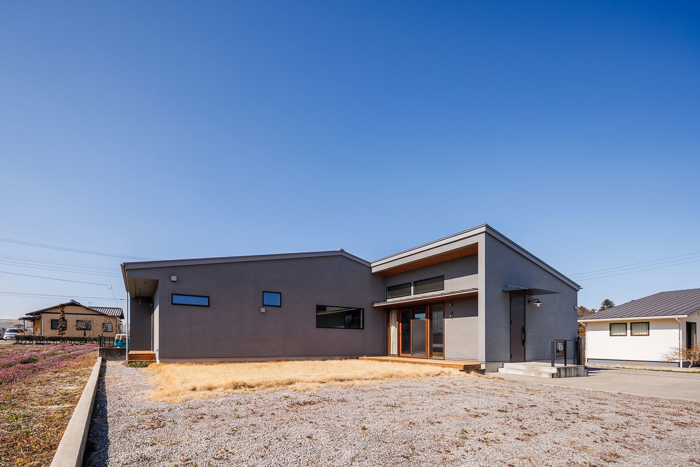Ｌ型に配置したグレーと木が映える外観
