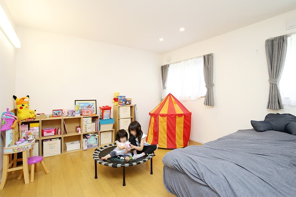 緑に開いた「くの字」の平屋の家