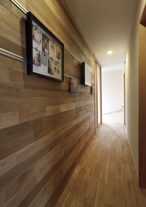 廊下はナラフローリングの壁にピクチャレールを埋込む